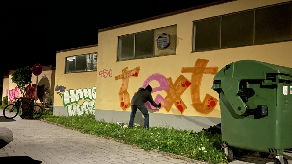 Max trägt dunkle Kleidung, über dem Gesicht eine FFP2-Maske. Er will unerkannt bleiben. Doch im Licht der Straßenlaternen kommt selbst der kleinste Farbklecks auf der buttergelben Wand zum Vorschein. Max trägt dunkle Kleidung, über dem Gesicht eine FFP2-Maske. Er will unerkannt bleiben. Doch im Licht der Straßenlaternen kommt selbst der kleinste Farbklecks auf der buttergelben Wand zum Vorschein.
